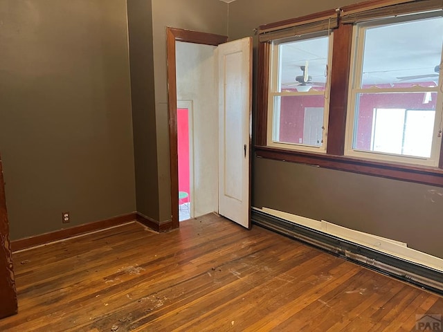 empty room featuring baseboards and hardwood / wood-style floors