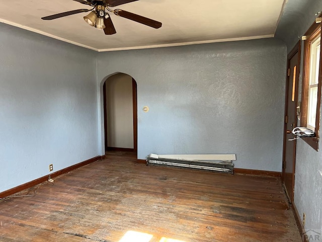 unfurnished room featuring arched walkways, hardwood / wood-style floors, and baseboards