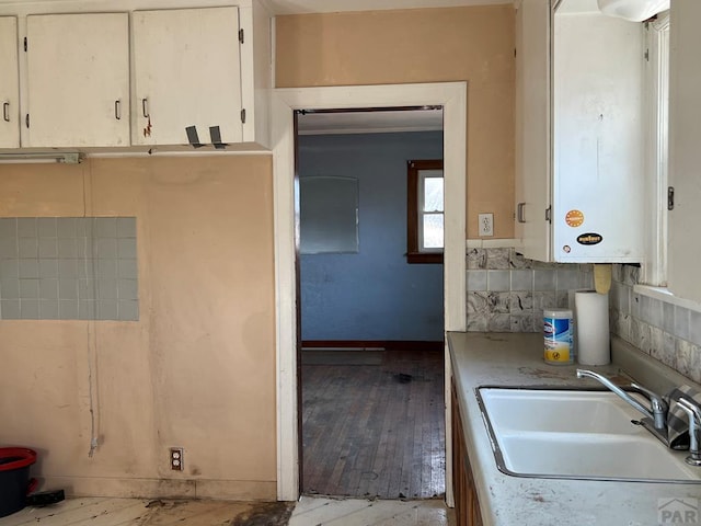 kitchen featuring white cabinets, a sink, and light countertops