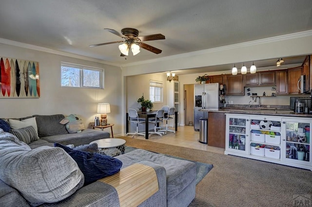 living area featuring light carpet, a ceiling fan, and crown molding