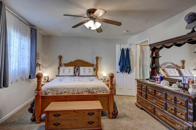 bedroom featuring a ceiling fan, light colored carpet, and baseboards