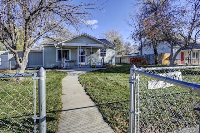 bungalow-style home with covered porch, a fenced front yard, and a front yard