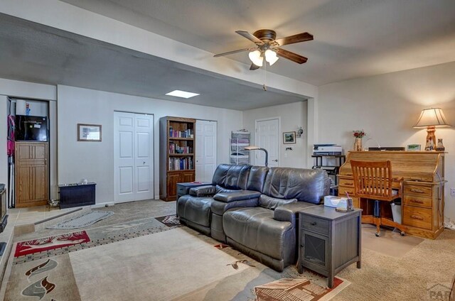 living room featuring light carpet and ceiling fan