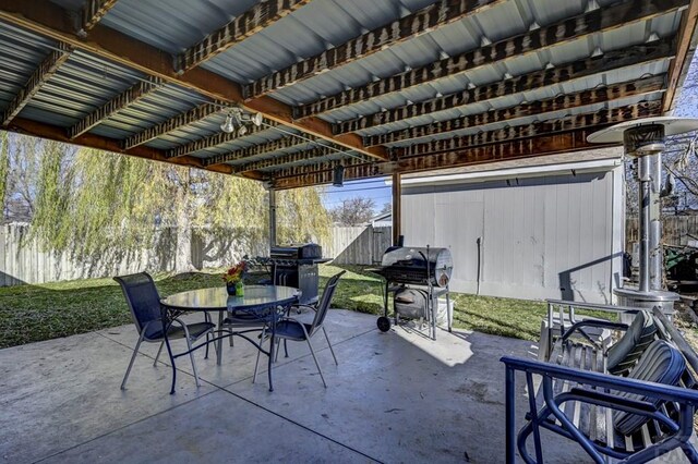 view of patio with outdoor dining area, a fenced backyard, and grilling area