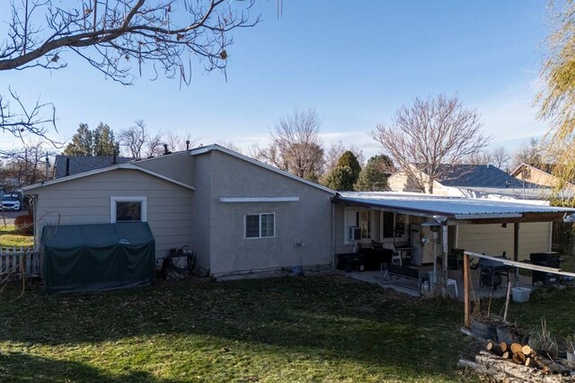 rear view of property with stucco siding, metal roof, and a yard