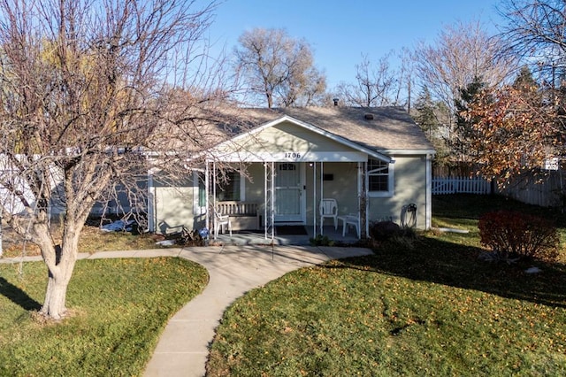 bungalow-style home with driveway, roof with shingles, fence, a front lawn, and a porch