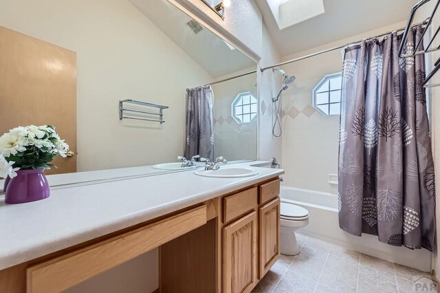 bathroom with toilet, visible vents, vanity, lofted ceiling with skylight, and shower / bath combo