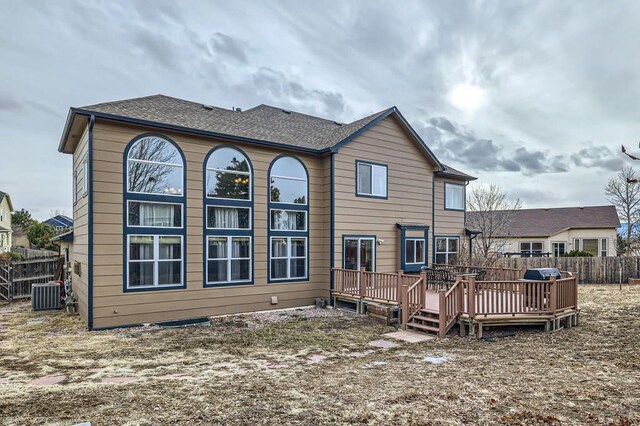 back of property with roof with shingles, cooling unit, a wooden deck, and fence