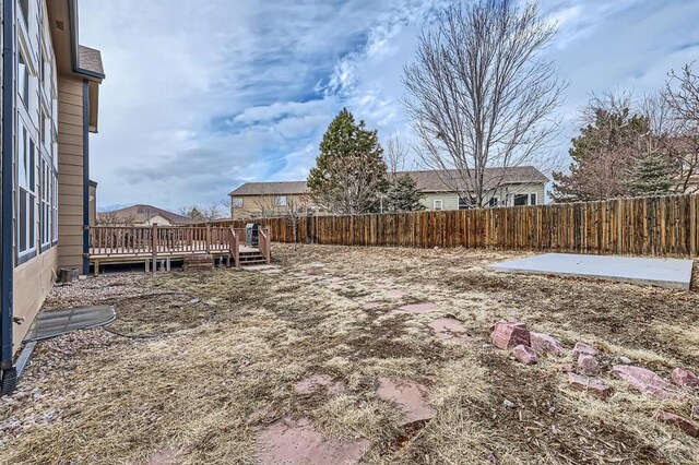 view of yard with a fenced backyard, a deck, and a patio