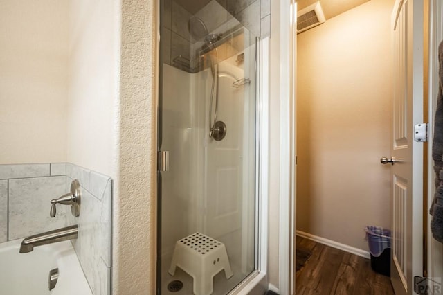 bathroom featuring a stall shower, wood finished floors, visible vents, and baseboards