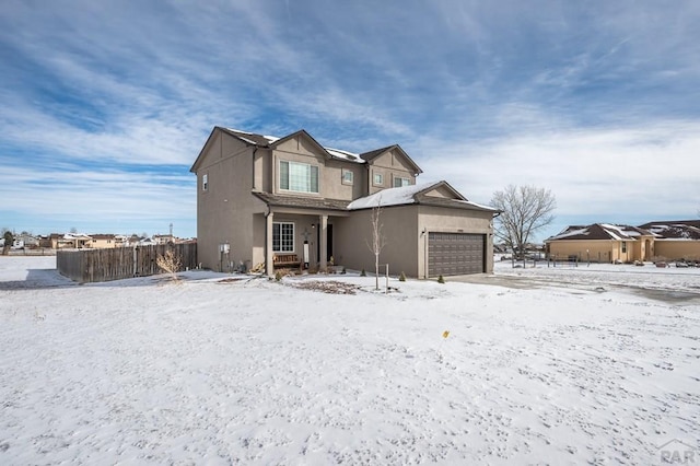 view of front of house featuring a garage, fence, and stucco siding