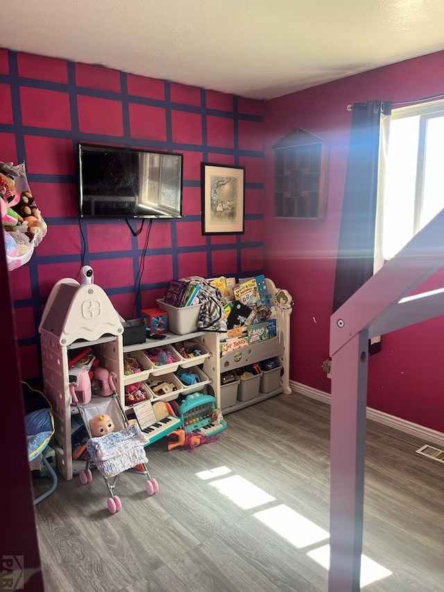 bedroom featuring wood finished floors, visible vents, and baseboards