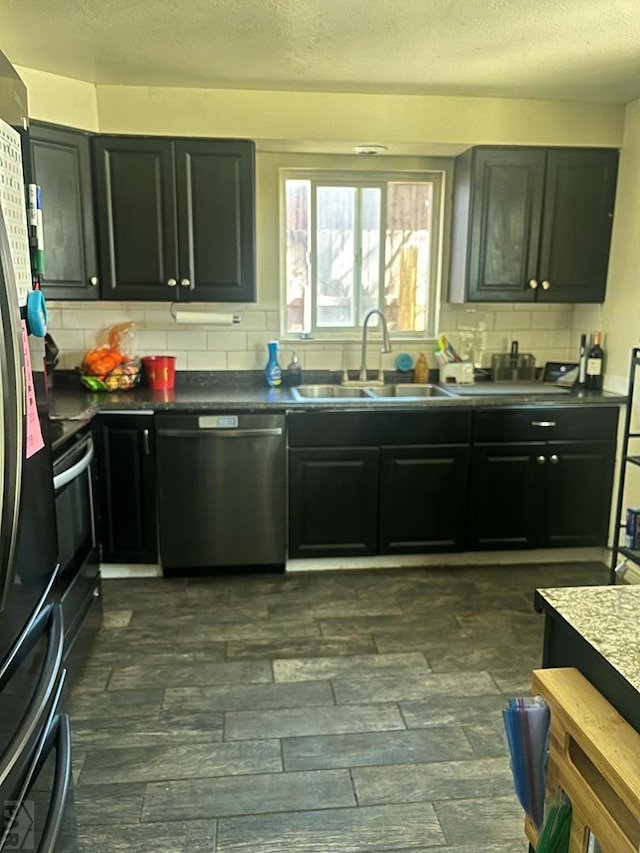 kitchen featuring dishwasher, backsplash, a sink, and a textured ceiling