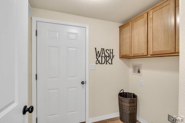 laundry room featuring hookup for a washing machine, cabinet space, and baseboards