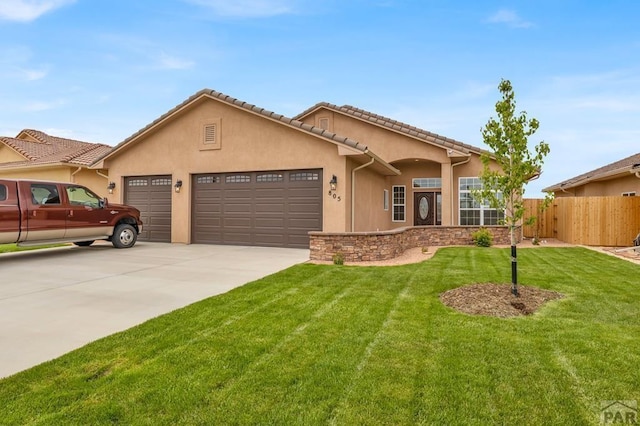 view of front of house featuring driveway, an attached garage, fence, a front lawn, and stucco siding