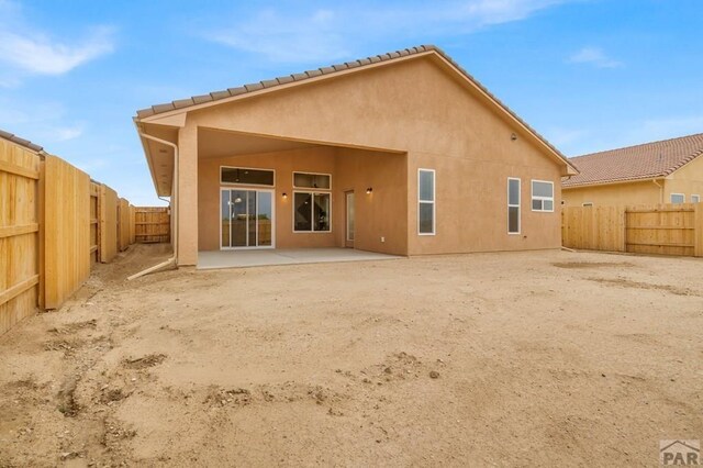 back of house featuring a patio area, a fenced backyard, and stucco siding