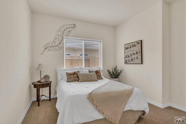 bedroom featuring light colored carpet and baseboards