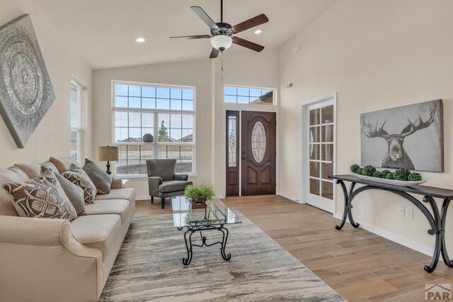 living room with baseboards, recessed lighting, and light wood-style floors