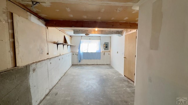 empty room featuring electric panel and unfinished concrete flooring