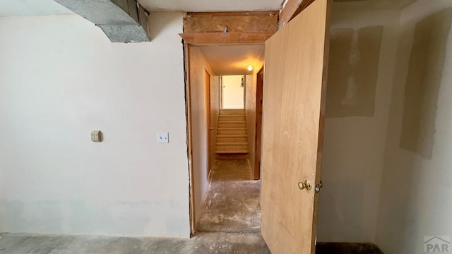 hall with stairway and unfinished concrete floors