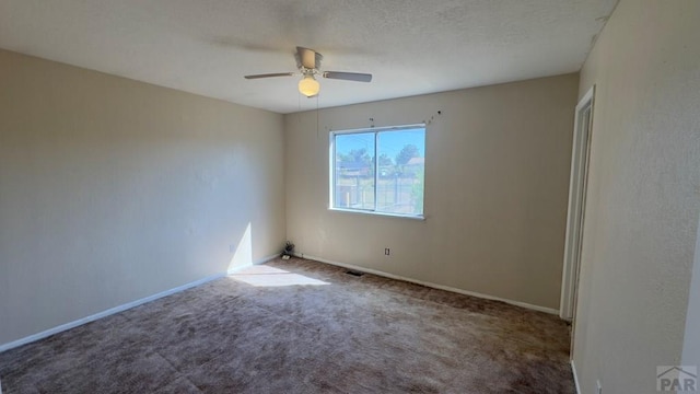 carpeted empty room with ceiling fan, visible vents, and baseboards