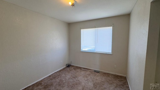 empty room with light carpet and baseboards