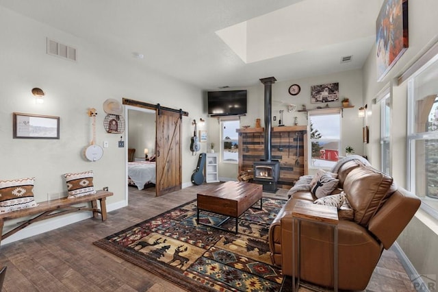 311 Knickerbocker Rd, Silver Cliff, CO 81252 - living room with a barn door, a wood stove, wood finished floors, and baseboards