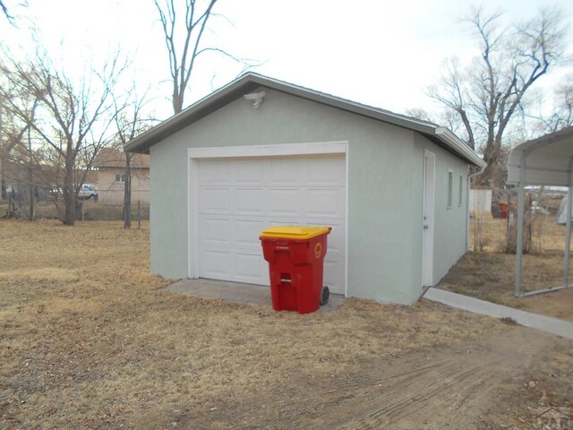 detached garage featuring dirt driveway