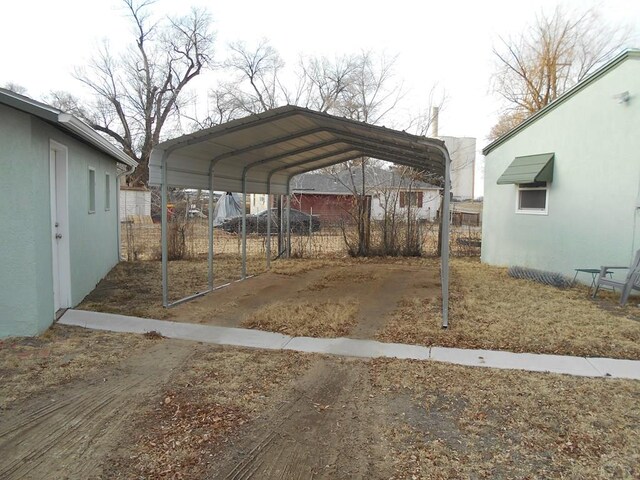 view of parking with a carport and fence