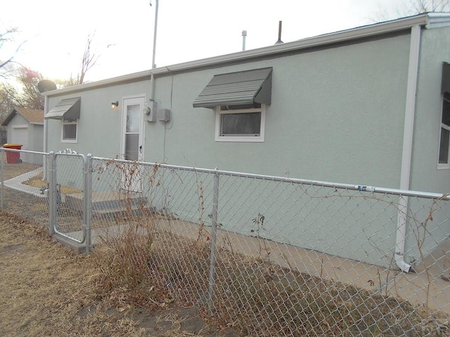 view of property exterior with fence and stucco siding