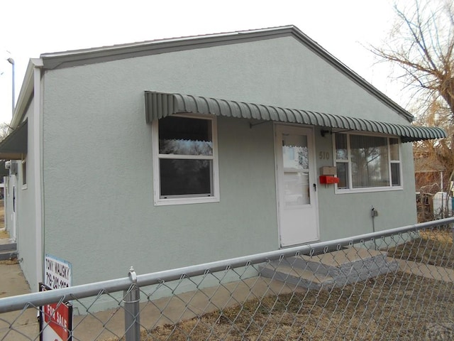 view of home's exterior featuring fence and stucco siding