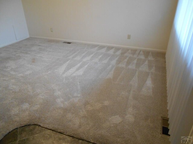 unfurnished room featuring light colored carpet and visible vents