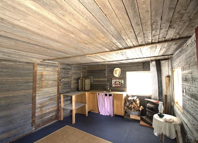 basement with wooden walls, wood ceiling, and dark carpet
