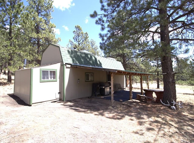 view of outbuilding featuring a hot tub and an attached carport