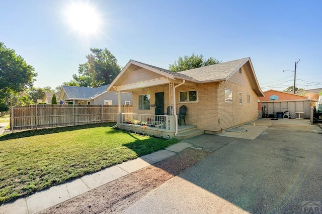 1908 E 5th St, Pueblo, CO 81001 - view of front facade featuring covered porch, brick siding, and roof with shingles