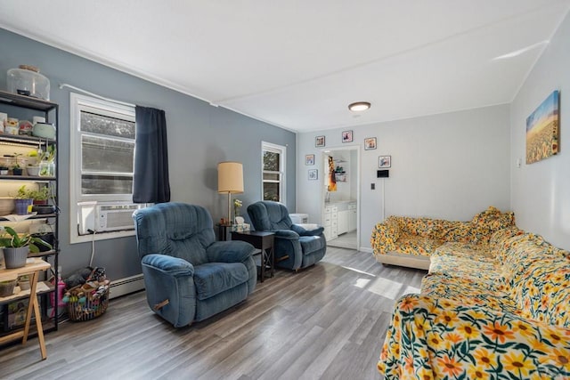 1908 E 5th St, Pueblo, CO 81001 - living area featuring plenty of natural light, cooling unit, wood finished floors, and a baseboard heating unit