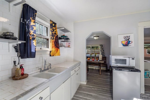 1908 E 5th St, Pueblo, CO 81001 - kitchen featuring white microwave, open shelves, tile countertops, and backsplash