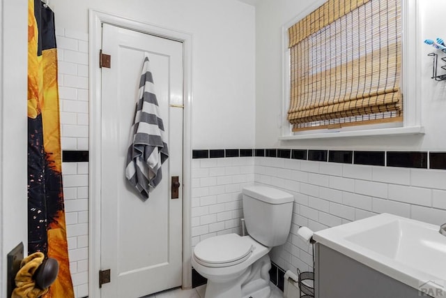 1908 E 5th St, Pueblo, CO 81001 - bathroom featuring vanity, toilet, tile walls, and a wainscoted wall