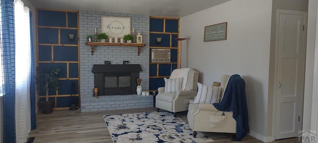 living room featuring a fireplace, wood finished floors, and baseboards