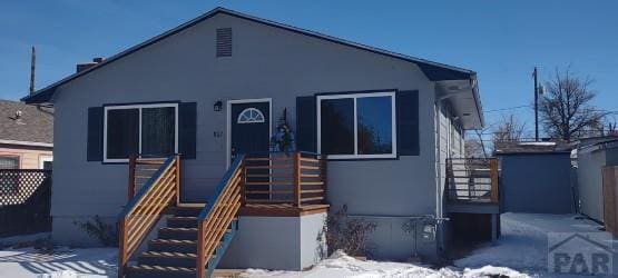 bungalow featuring stairs and stucco siding