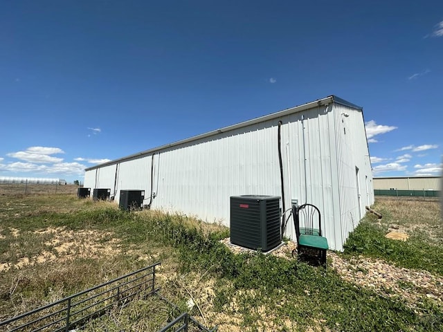 view of pole building with fence and cooling unit