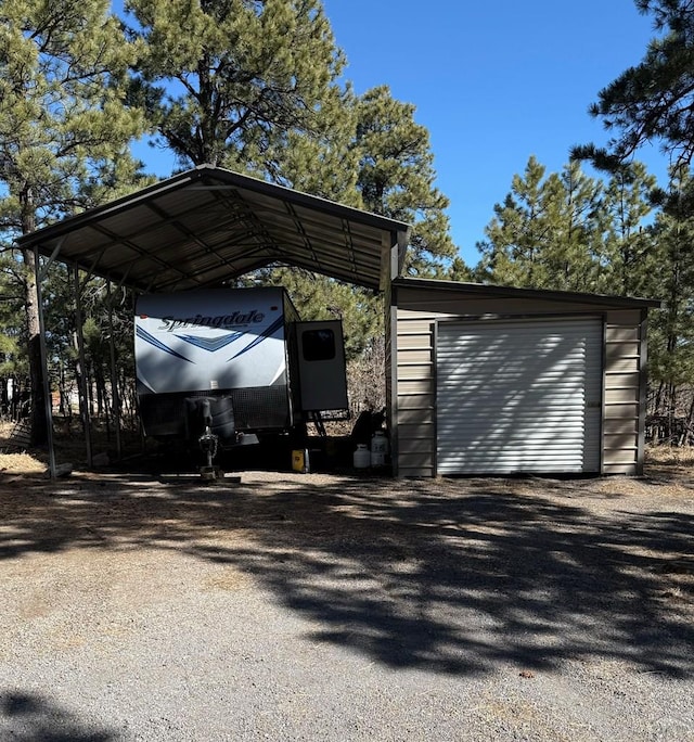 view of parking / parking lot with gravel driveway and a detached carport