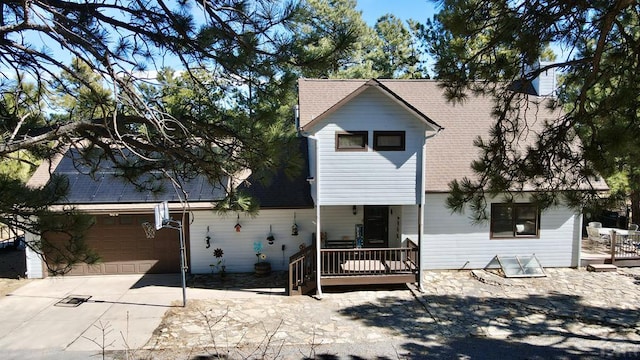 view of front of house with a shingled roof and concrete driveway