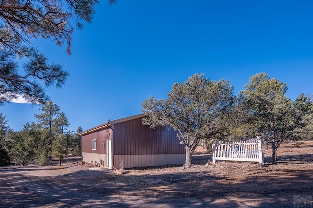 view of property exterior featuring fence and an outbuilding