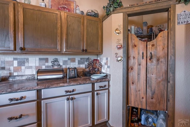 kitchen featuring dark stone countertops and decorative backsplash