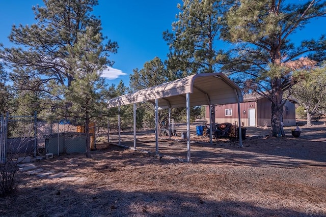 view of yard featuring a carport, fence, and driveway