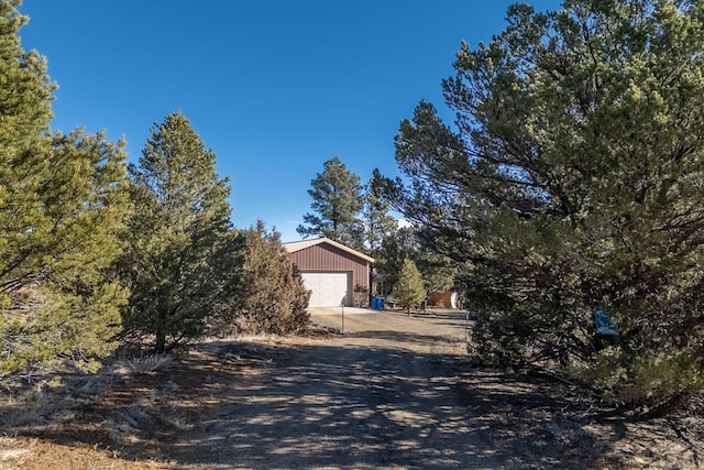 view of home's exterior featuring driveway and an outdoor structure