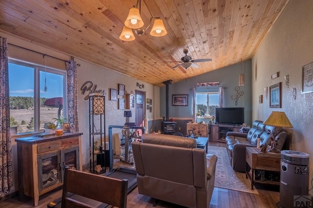 living room featuring wooden ceiling, wood finished floors, a wood stove, vaulted ceiling, and a fireplace