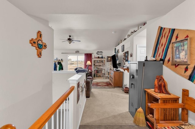 hall featuring light colored carpet, vaulted ceiling, and an upstairs landing