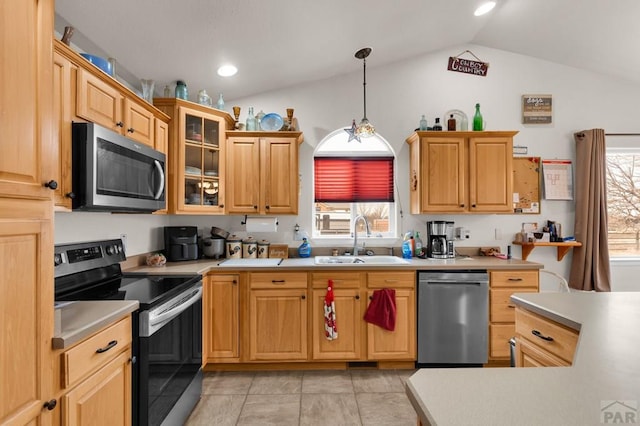 kitchen featuring glass insert cabinets, hanging light fixtures, stainless steel appliances, light countertops, and a sink